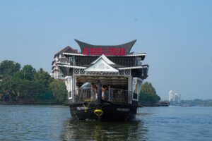 JK Royal Cruise houseboat with guests aboard cruising the Kerala backwaters