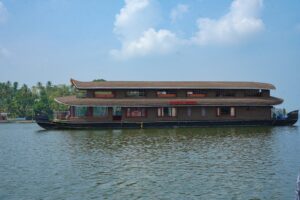 JK Royal Cruise houseboat with 'Royal Cruise' signage on Ashtamudi Lake