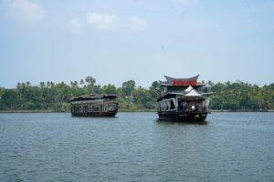 Two JK Royal Cruise houseboats docked on Ashtamudi Lake, Kerala